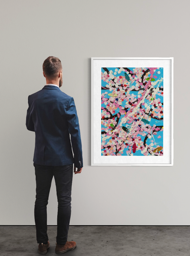 <img alt="Installation view of Damien Hirst's Gilded Blossom, unframed work displayed on a white gallery wall, with a visitor standing with their back to the camera contemplating the piece." />
